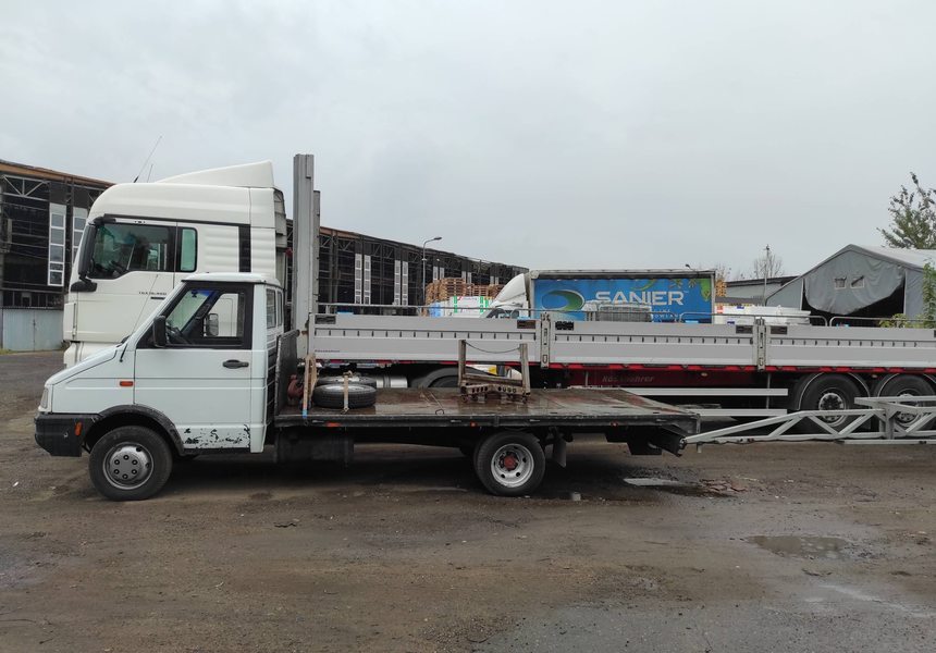 Auto burtowe i naczepa burtowa na placu firmy transportowej