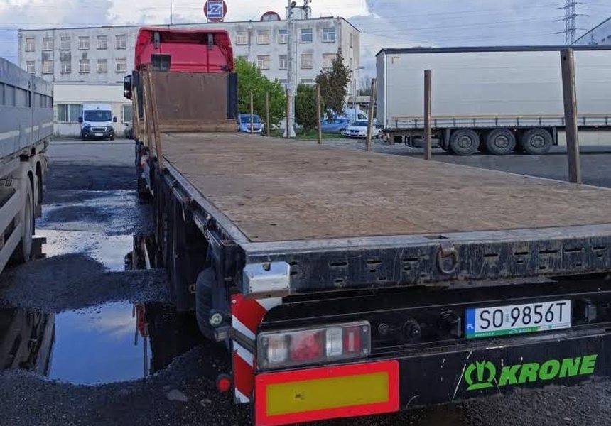 Naczepa platforma bez burt zaparkowana na placu